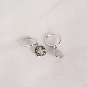 Macro view of S925 sterling silver hoop earrings with starburst cubic zirconia charms