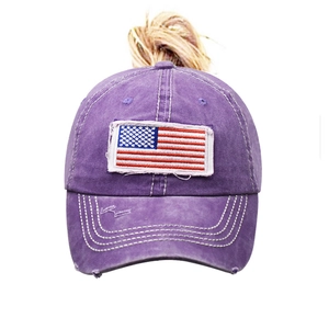 Close-up of embroidered American flag patch on washed purple cotton baseball cap