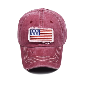 Close-up of distressed wine red cotton baseball cap with American flag embroidery