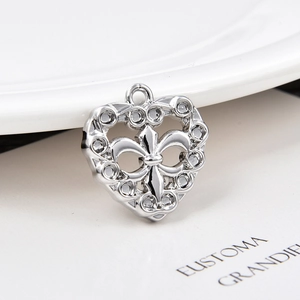 Detailed macro view of silver heart pendant with fleur-de-lis motif for DIY jewelry
