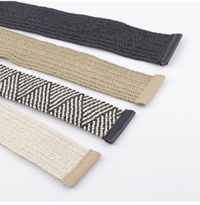 Détail de ceintures en paille tressée en quatre motifs dont noir, kaki et chevrons