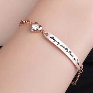 Detail of rose gold bracelet featuring engraved sister quote and heart crystal charm