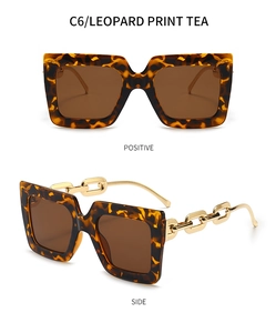 Détail de lunettes de soleil léopard avec branches chaîne dorée et verres thé
