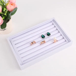Top view of white velvet jewelry tray featuring multi-slot rows for ring and earring storage