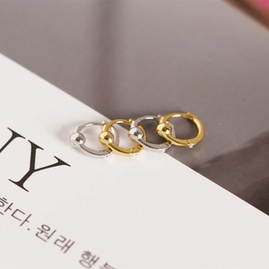 Close-up of gold and silver S925 sterling silver hoop earrings with geometric beads