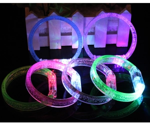Macro shot of 6 glowing LED bracelets with transparent bubble texture on reflective surface