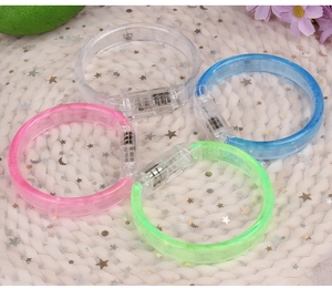 Close-up of four colorful LED glow bracelets in pink, green, blue, and clear colors