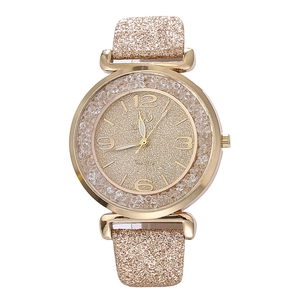 Vista macro del quadrante dell'orologio al quarzo dorato con polvere glitterata e strass