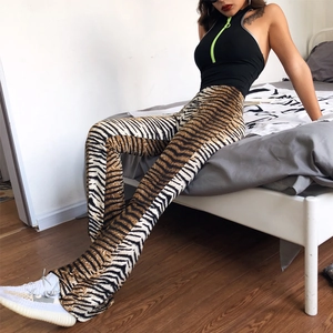 Detail view of high waist leopard print flare pants styled with a black halter top
