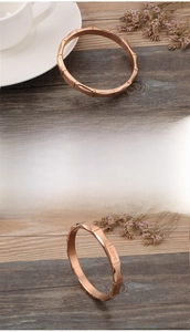 Detailopname van de roségouden LOVE hartarmband met gepolijste segmenten in bamboestijl