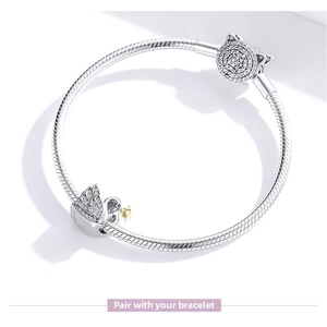 Detailed view of a 925 sterling silver snake chain bracelet with swan and cat charms