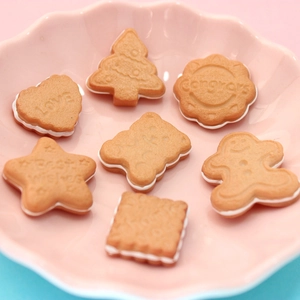 Close-up of assorted resin cookie charms with engraved text on a pink plate for DIY