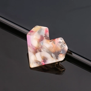 Detail of heart-shaped marble acetate hair clip with multi-color jelly texture and metal pin
