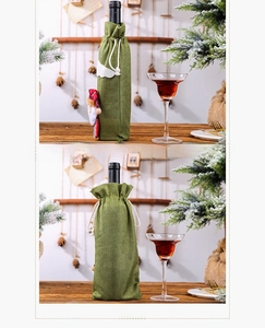 Detail of green burlap Christmas wine bottle cover with Santa doll and snowflake design