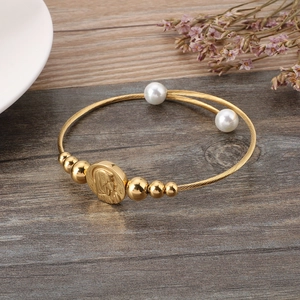 Elegant 18k gold plated open wire bracelet with saint pendant and ivory beads