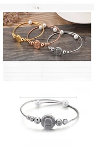 Detailed view of religious steel bracelets with Virgin Mary medal and shell pearls