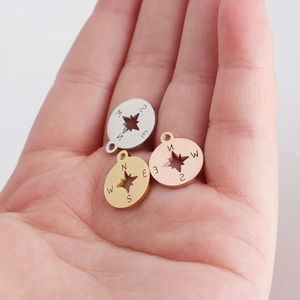 Three stainless steel compass pendants in silver, gold, and rose gold finishes