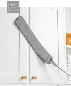 Close-up of extendable gap duster cleaning dust from a high white cabinet top effortlessly