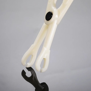 Close-up of a disposable plastic piercing clamp with round mouth in white and black