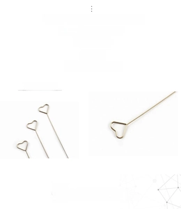 Detailed macro of gold heart-shaped metal card holders for floral arrangements and decor