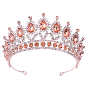 Close-up of rose gold bridal crown featuring teardrop orange crystals and white rhinestones