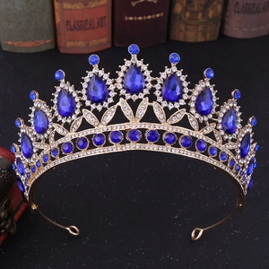 Detailed macro of gold Baroque crown with teardrop blue crystals and white rhinestones