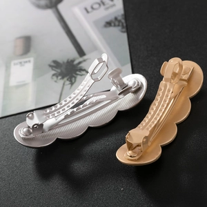 Détail arrière de barrettes géométriques en or et argent mat avec fermoir à ressort