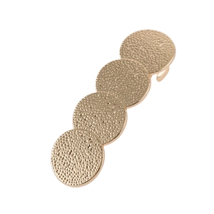 Détail de quatre disques géométriques en or mat avec texture martelée sur une pince à cheveux