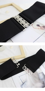 Detail of black elastic wide waist belt with silver interlocking round metal buckle