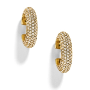 Detail of gold C-shaped clip-on earrings with pavé set sparkling crystals on white base