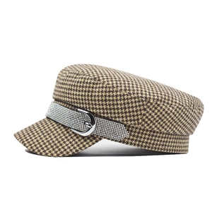 Detail of vintage houndstooth newsboy hat with rhinestone band and silver metal buckle