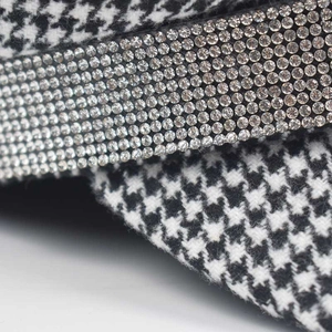 Detailed view of the black and white houndstooth fabric with rows of sparkling rhinestones