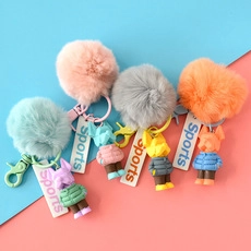 Detailed view of colorful plush heart keychains with cute cartoon figures in five colors