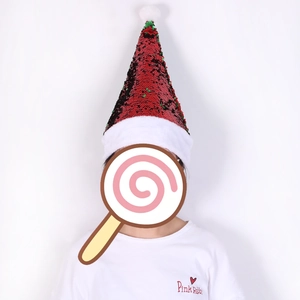 Detail of red and green reversible sequin Christmas hat with plush white trim and pompom