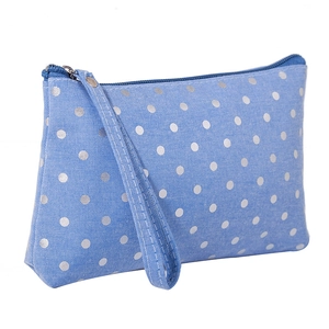 Portable blue fabric makeup bag with white polka dots, zipper closure and wrist strap