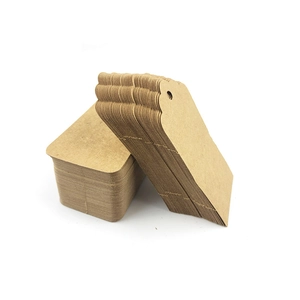 Detail shot of stacked brown kraft paper gift tags showing thickness and pre-punched holes