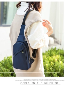 Detail of navy blue waterproof nylon chest bag with headphone port and metal accents