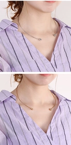 Detail of minimalist stainless steel neck ring in gold and silver showing hexagon charm