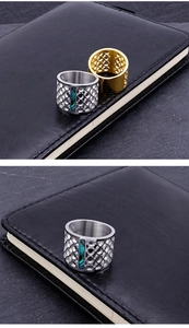 Detailed shot of hollow geometric ring with blue shell inlay in gold and silver finish