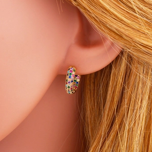 Rainbow cubic zirconia gold hoop earrings shown on ear for a stylish fashion look
