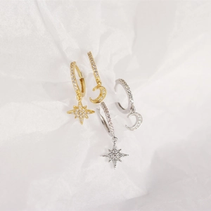 Detailed view of asymmetric star and moon hoop earrings in gold and silver finish