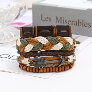 Detail view of multi-layer braided leather bracelets set with arrow charm and wooden beads