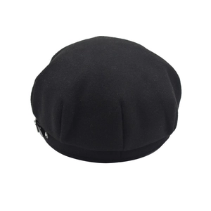 Detail of black wool beret with leather strap and silver metal buckle decoration