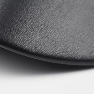Macro shot of high-quality black litchi texture PU leather on a stylish newsboy hat