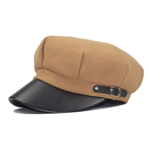 Detail of camel wool baker boy hat featuring black leather brim and silver metal buckle