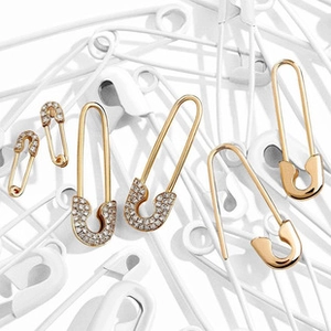 Detailed view of gold paperclip earrings with crystal inlay on a white background