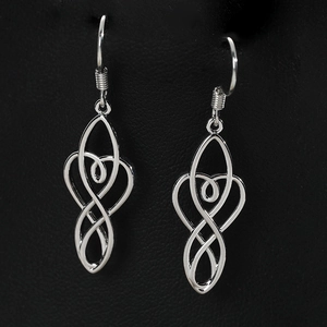 Macro shot of silver celtic knot earrings with heart shape on black leather background