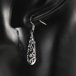 Detailed view of silver teardrop hollow earrings with intricate vintage filigree patterns