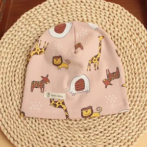 Detailed view of pink cotton baby beanie featuring cartoon giraffe and lion prints