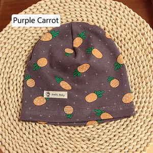 Detail of purple cotton baby hat featuring cute orange carrot prints and woven brand label